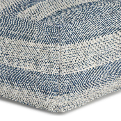 Close-up of the Clay - Square Pouf, Upholstered, showing a woven texture with blue and white horizontal stripes in a checkered pattern on the corner.
