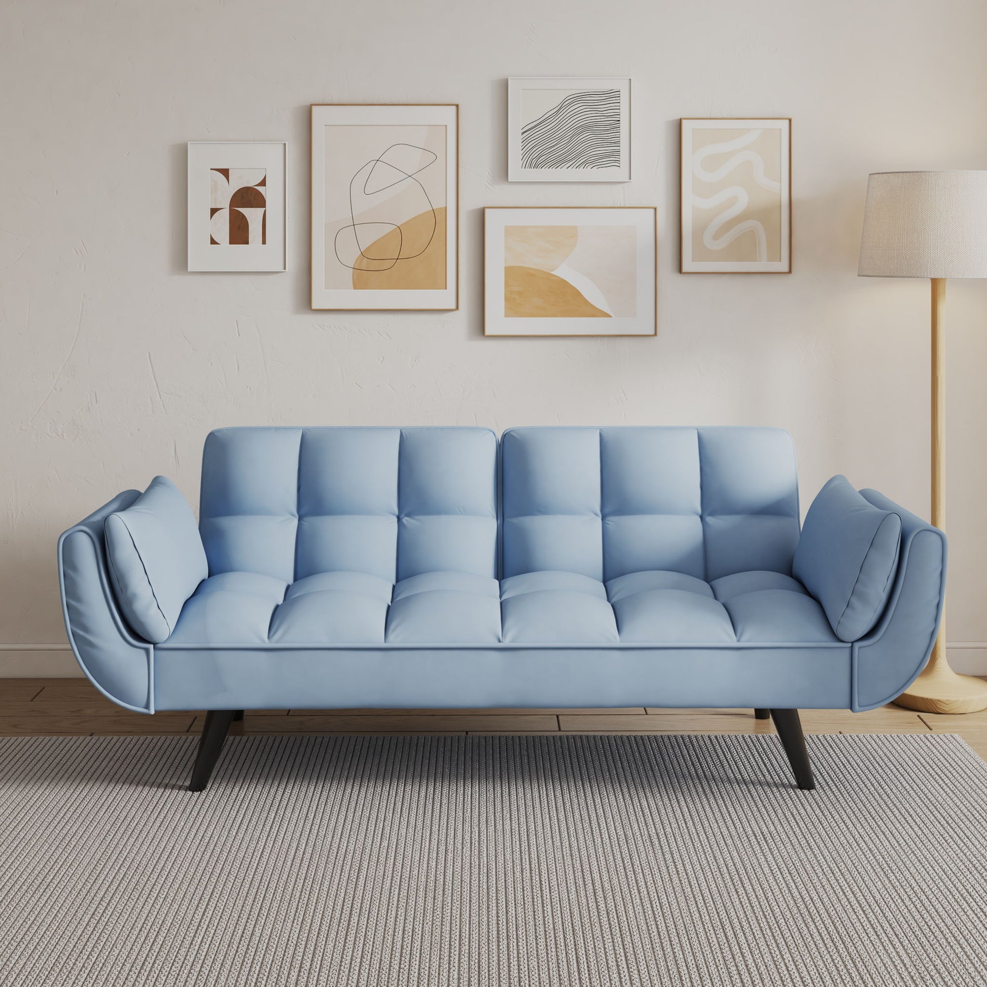 A modern living room featuring the Sofa Soft Two Armrests with throw pillows, a gray rug, floor lamp, and five abstract art pieces in light wood frames on a white wall.