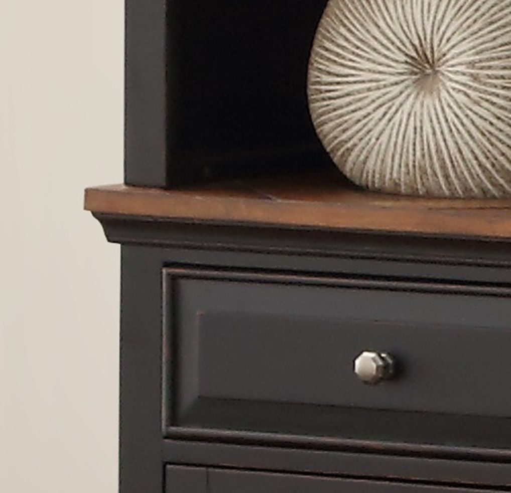 A close-up of the Brighton - Pier dark wooden cabinet featuring a drawer with a silver knob and a partially visible round, textured beige decorative object on top.