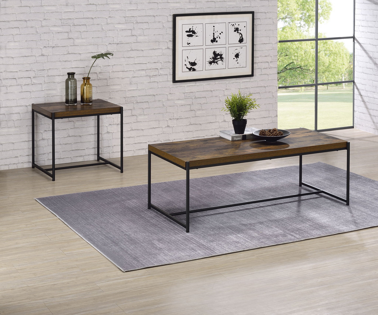 A modern living room featuring the Lennox 3 Piece Coffee And End Table set on a gray rug, with a brick wall, framed art, vases, a plant, and a large window revealing greenery outside.