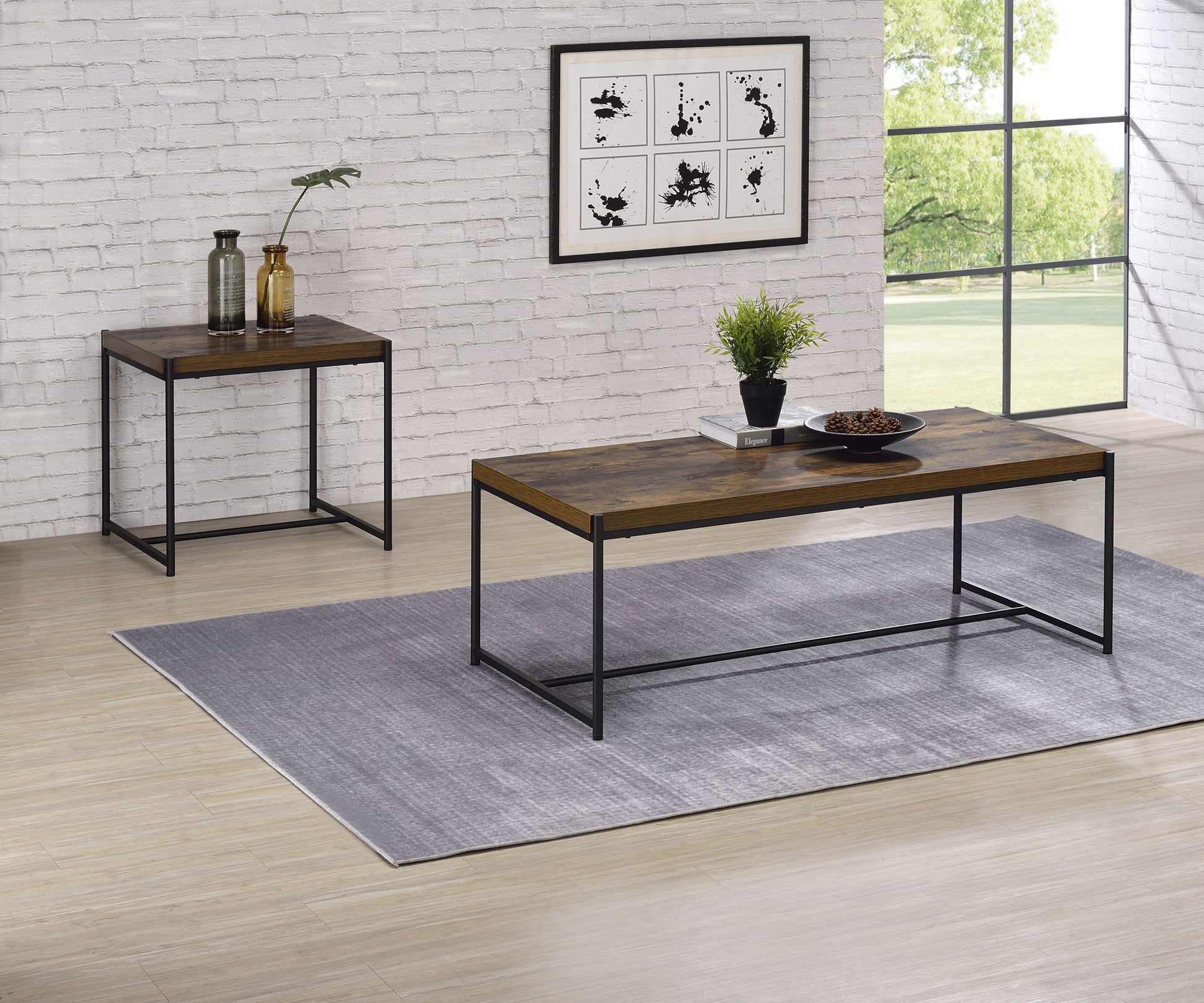 A modern living room featuring the Lennox 3 Piece Coffee And End Table set on a gray rug, with a brick wall, framed art, vases, a plant, and a large window revealing greenery outside.