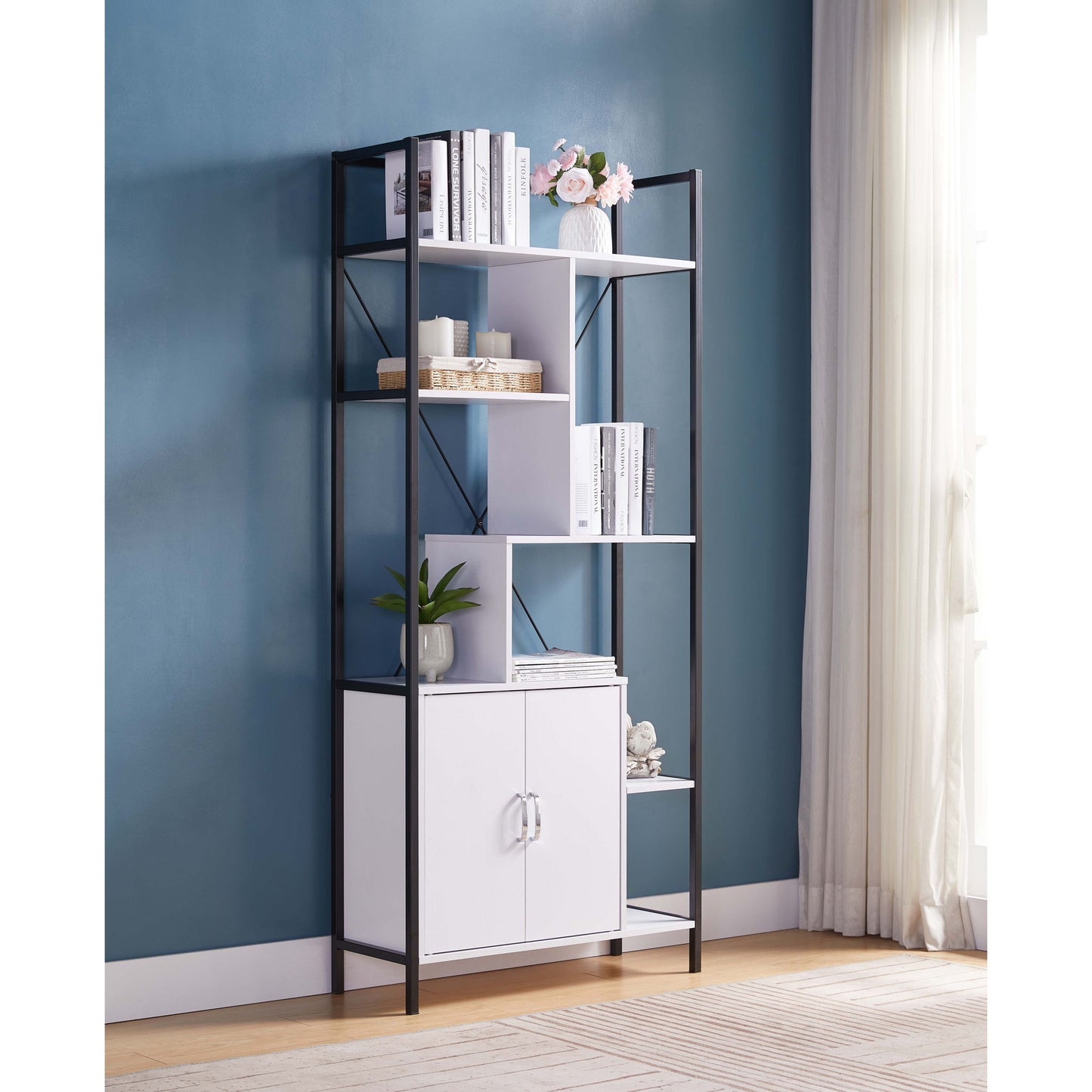 The Modern Bookcase With Two Door Storage Cabinet With Two Shelves, featuring a black metal frame and white shelves, stands against a teal wall. It holds books, plants, décor, and has a two-door cabinet below. Light enters through white-curtained windows.