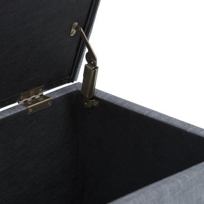 A close-up of the Sienna Upholstered Storage Ottoman Bench shows its open black fabric interior and metal hinge mechanism connecting the lid to the side.