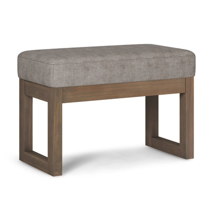 The Milltown Upholstered Ottoman Bench features a rectangular cushioned seat in light gray fabric and a sturdy brown-finished wooden base with open rectangular legs.