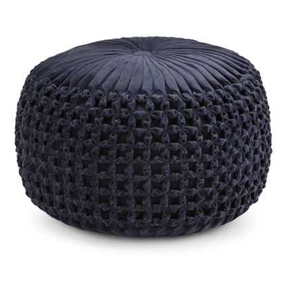The Renee - Handcrafted Round Pouf features a round, dark blue design with a pleated and tufted velvet top and intricately woven, knotted sides.