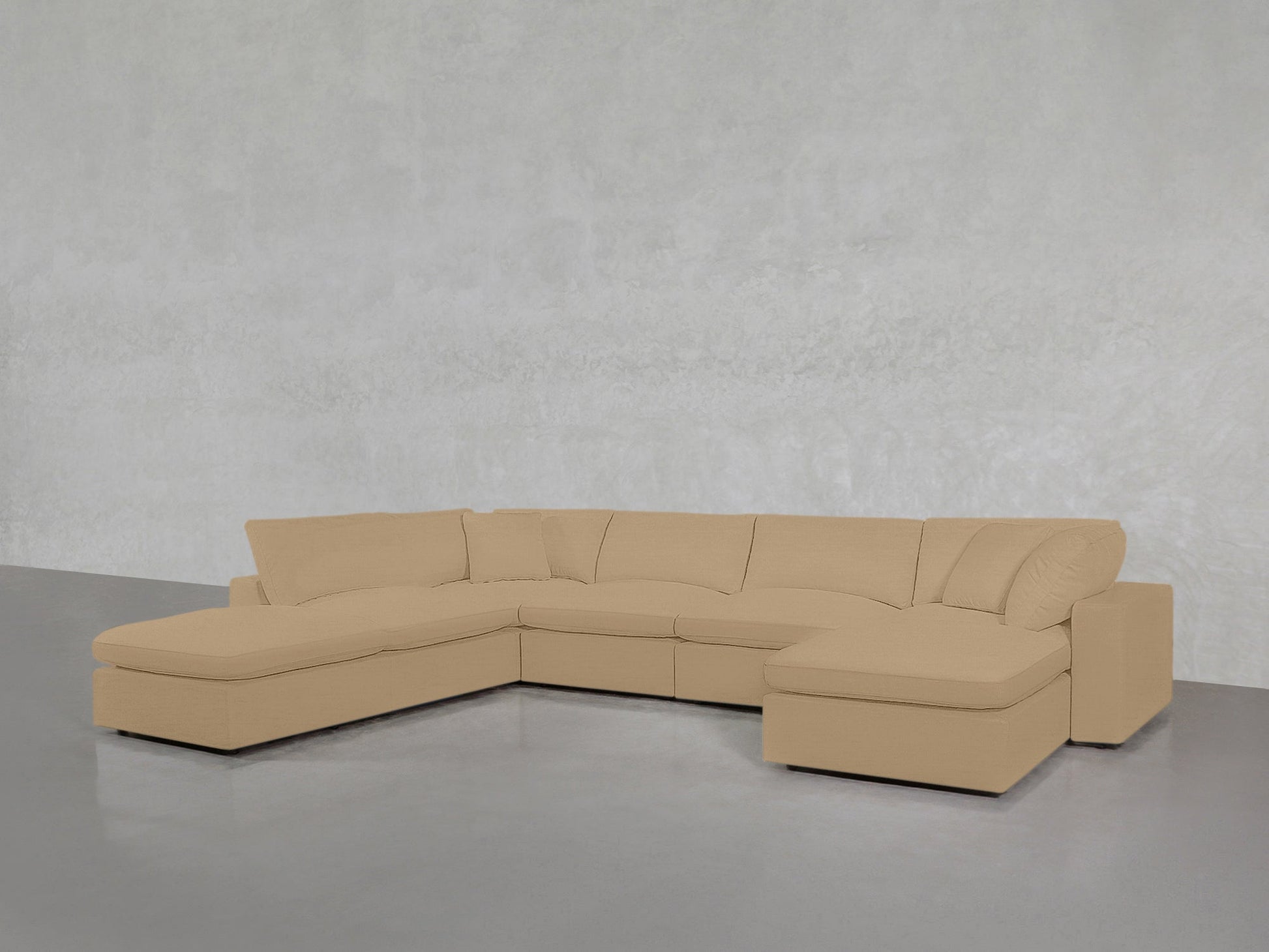 The 7-Seat Modular Chaise Corner Lounger Sectional, in beige with plush cushions and chaise lounges at both ends, is set against a light gray wall and smooth gray floor.