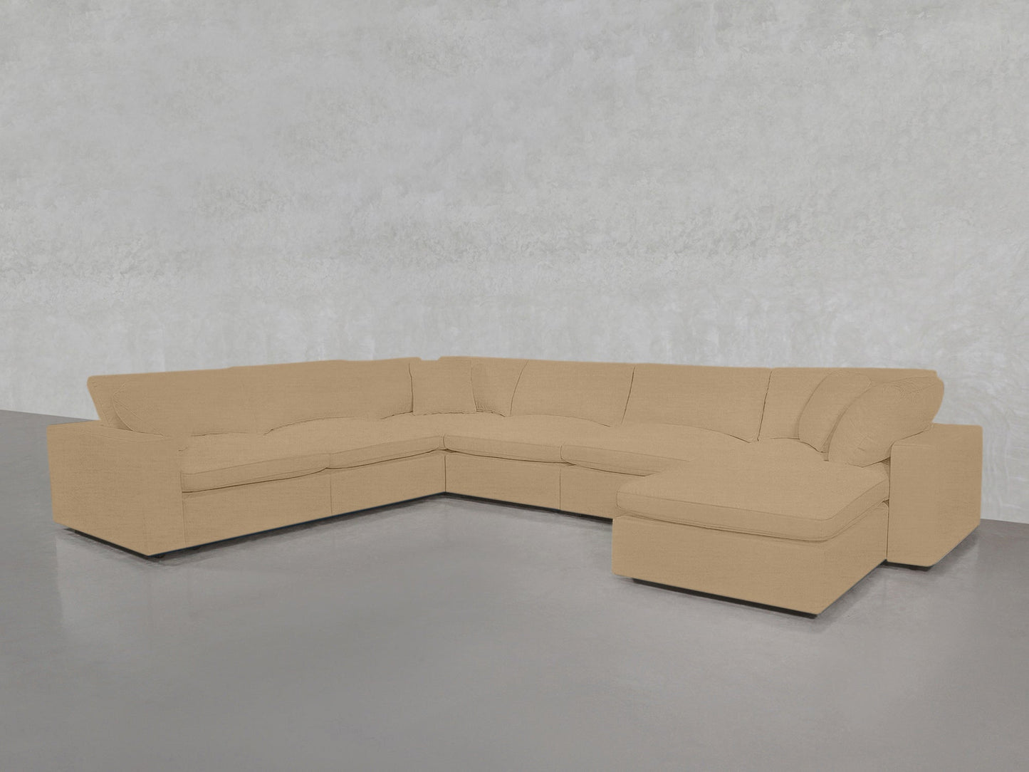 A 7-Seat Modular Chaise Corner Sectional with wide armrests is placed on a polished gray floor against a light gray textured wall.