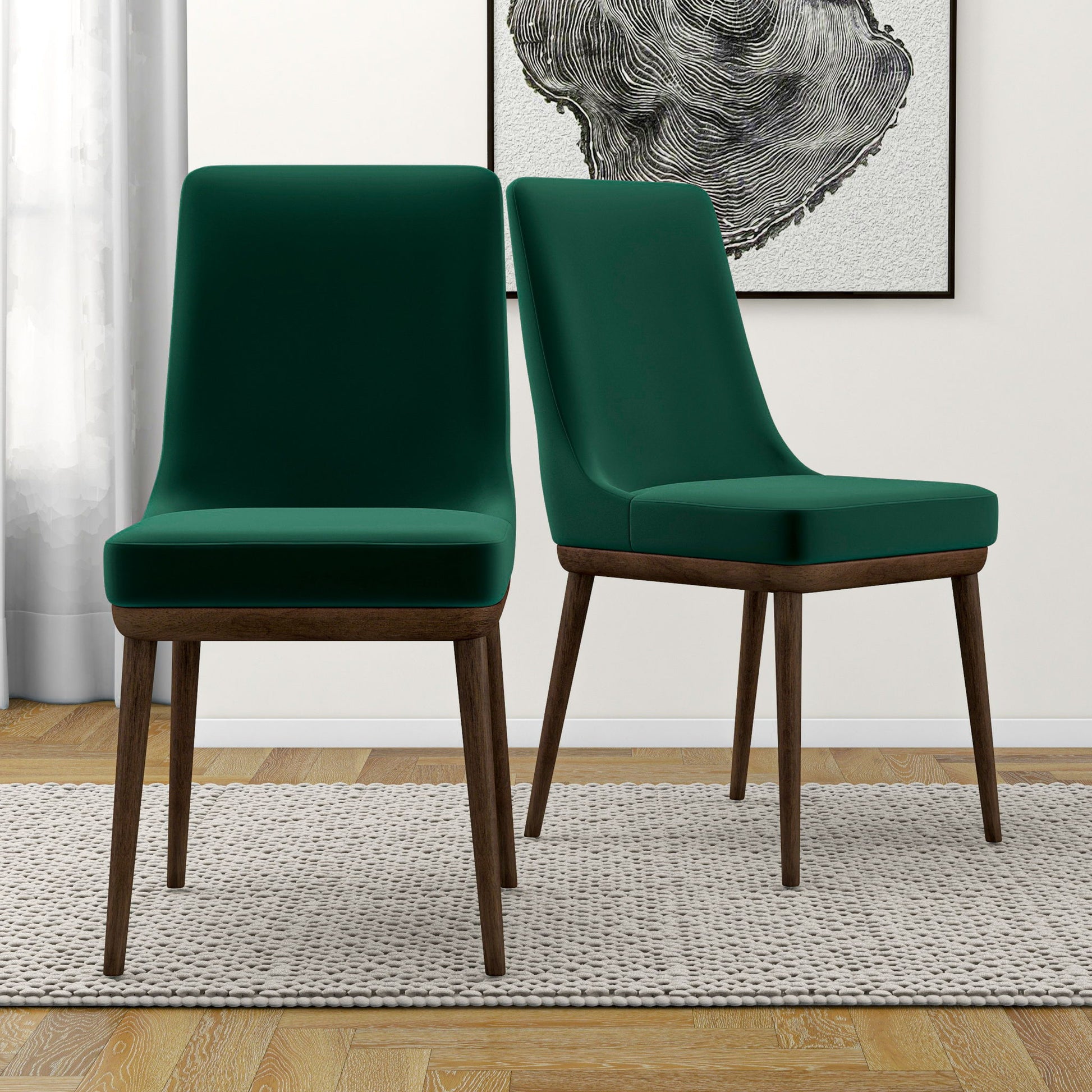 A set of two Kate Mid-Century Modern Dining Chairs are arranged on a textured beige rug in a bright room, with wooden floors, a curtain, and abstract black-and-white wall art in the background.