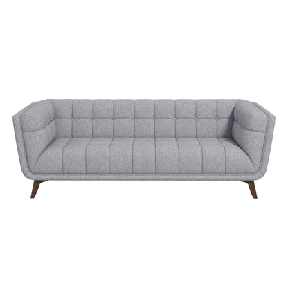 The Addison Mid-Century Modern Tufted Sofa features gray fabric, angled armrests, wooden legs, and tufted cushions, shown from the front on a white background.