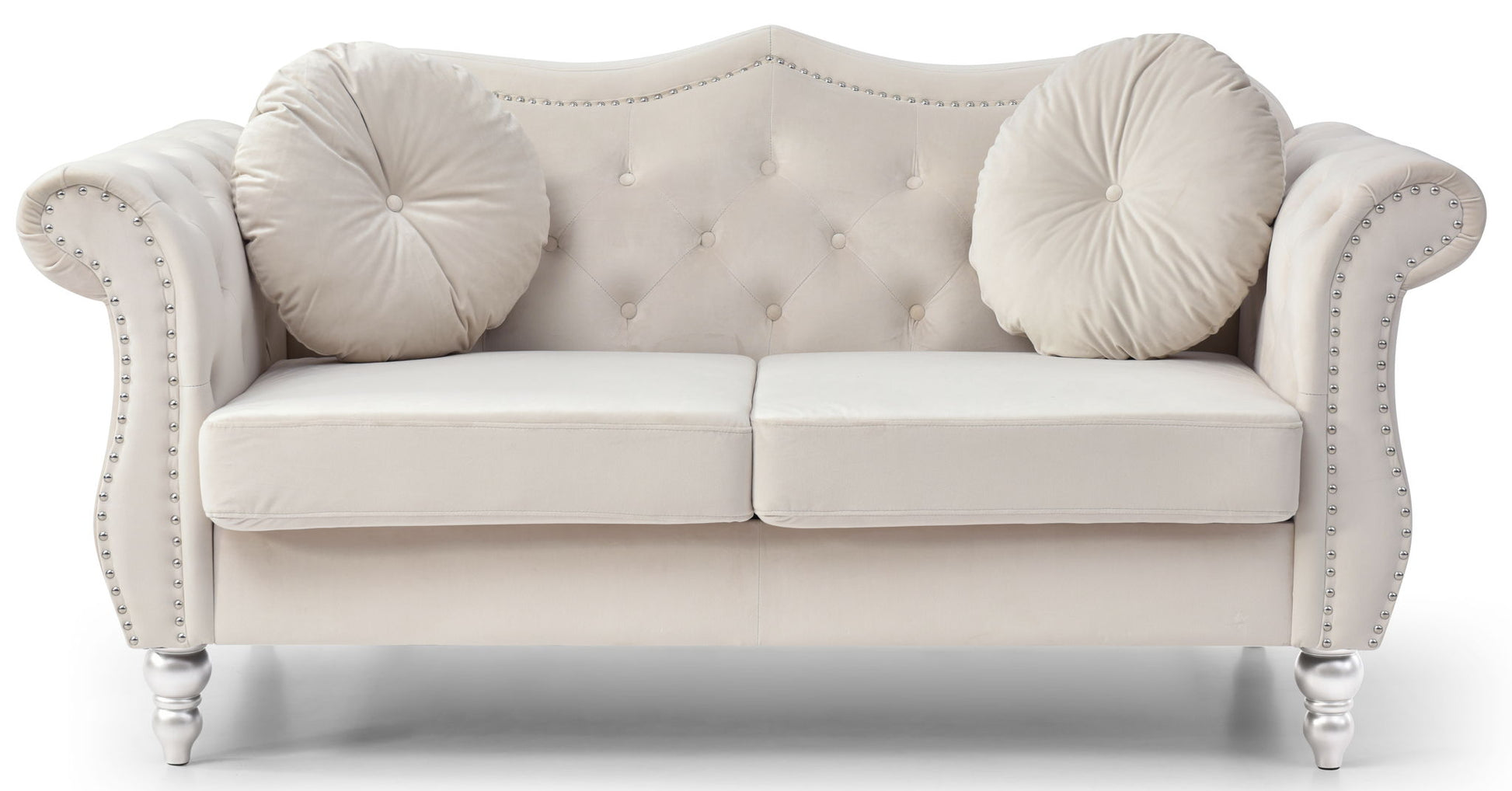 The Stylish Flared Arm Loveseat features plush light beige velvet, two seat cushions, a tufted backrest, curved armrests with silver nailhead trim, two round matching pillows, and short turned wooden legs.