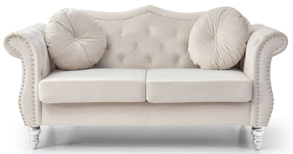 The Stylish Flared Arm Loveseat features plush light beige velvet, two seat cushions, a tufted backrest, curved armrests with silver nailhead trim, two round matching pillows, and short turned wooden legs.
