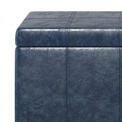 Close-up of the Dover Upholstered Storage Ottoman Bench in dark blue faux leather, featuring visible stitching and a textured surface. Image highlights the top and side corner against a white background.