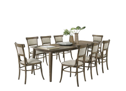 The Bistro Dining Table with Off White Fabric Dining Chairs set includes a wooden table and eight matching chairs with upholstered seats and backs. The table is styled with stacked plates, books, and a vase of green plants against a plain white background.