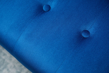 Close-up of the Comfort Compact Design Sofa Bed's blue upholstered fabric, featuring two round, fabric-covered buttons in a tufted pattern. The smooth, slightly shiny surface adds a touch of elegance to the design.