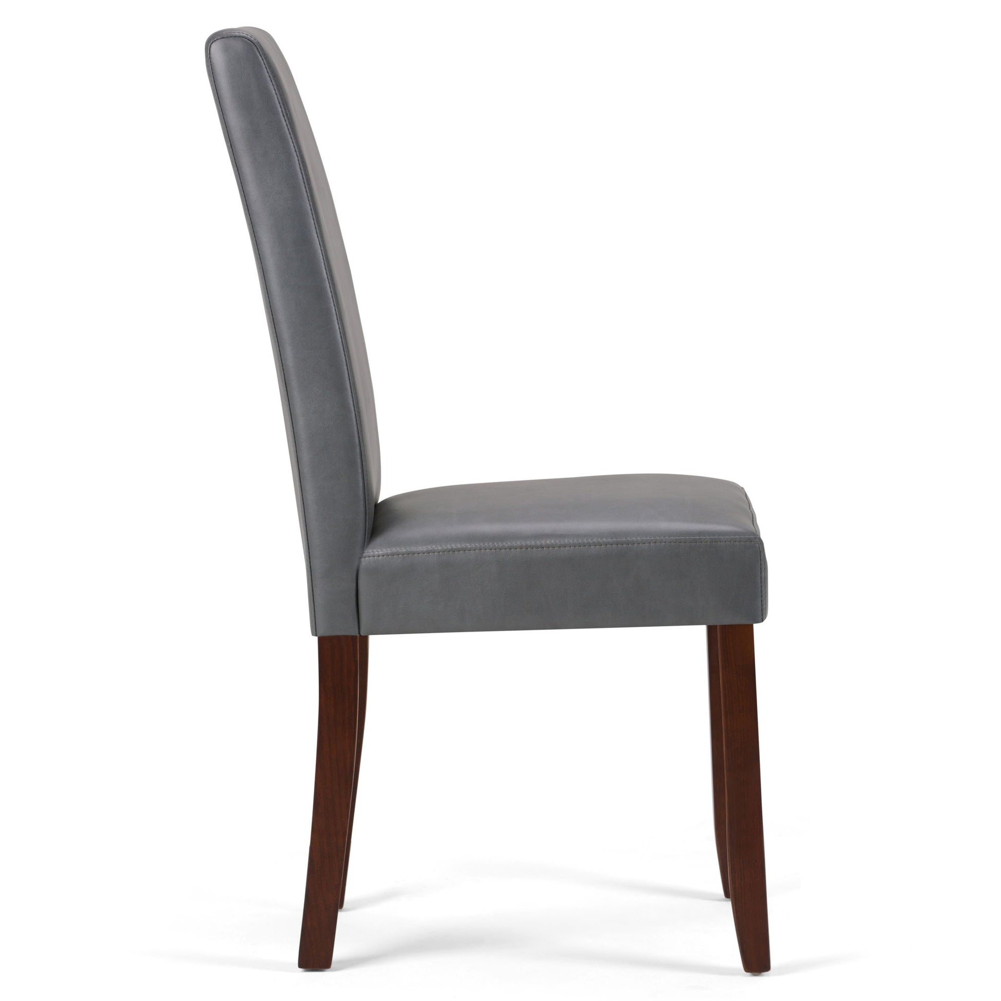 A side view of the Acadian - Upholstered Parson Dining Chair (Set of 2) shows its tall, padded gray leather backrest and seat, supported by four dark wooden legs.