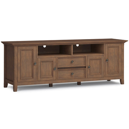 The Amherst Wide TV Media Stand in Rustic Natural Aged Brown features two central drawers, two open shelves above, and side cabinets with doors, plus cable management holes in the back panel.