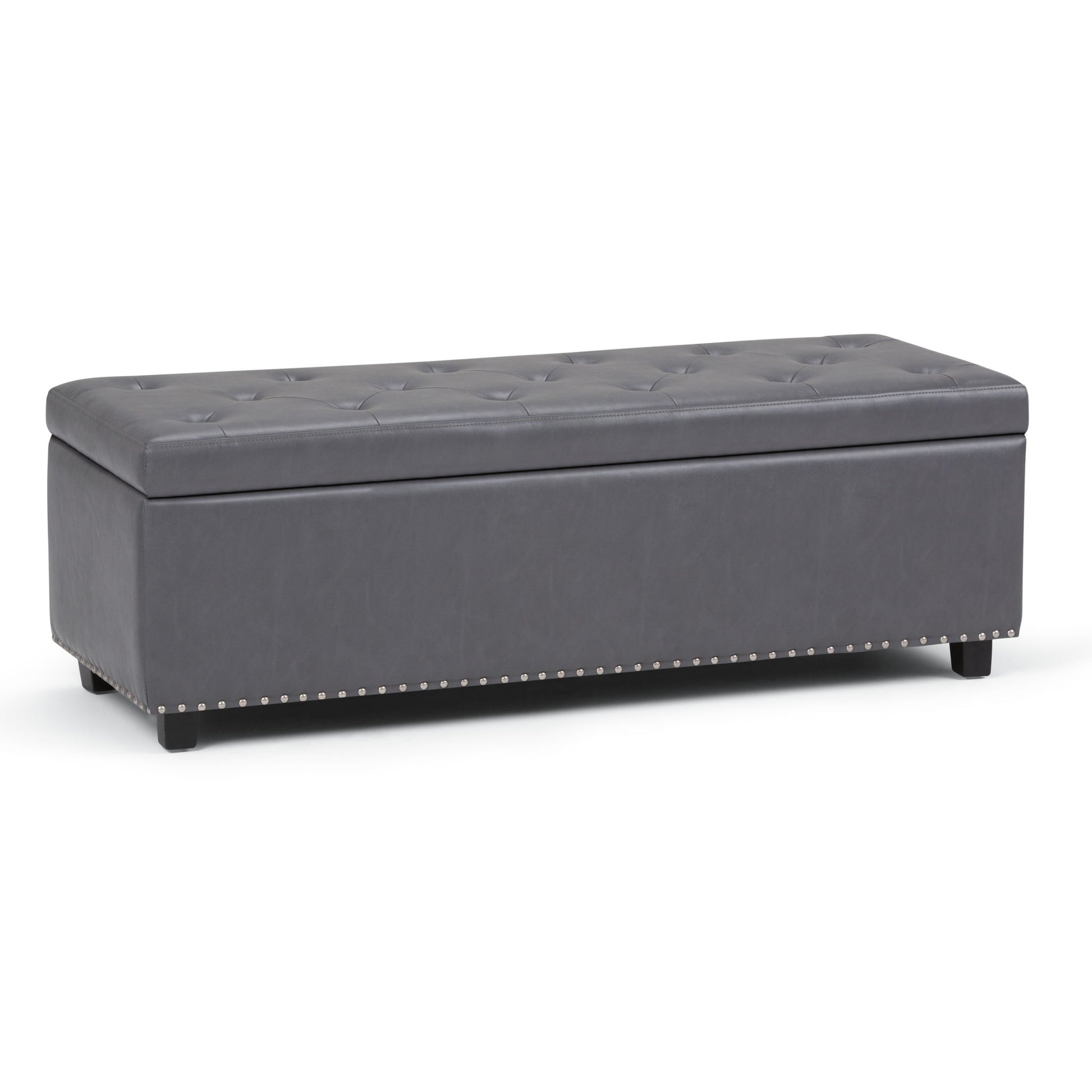 The Hamilton Upholstered Storage Ottoman features a rectangular, dark gray tufted design with short black legs and silver nailhead trim along the base, offering stylish storage for any space.