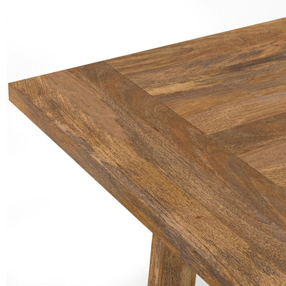 A close-up of the Whitley Dining Table in Burnt Wax Brown highlights the joint and textured natural wood grain on the tabletop corner.