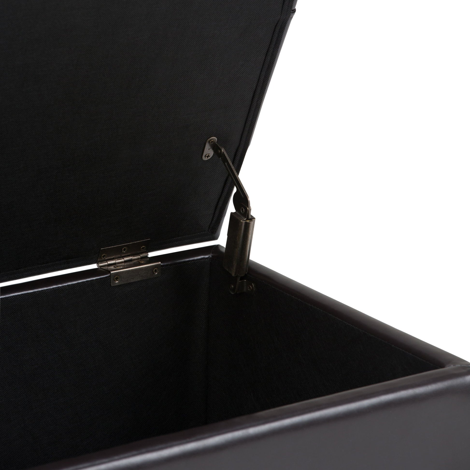 A close-up of the Sienna - Upholstered Storage Ottoman Bench showcases its inside corner, hinge, and lid support mechanism against a white background.