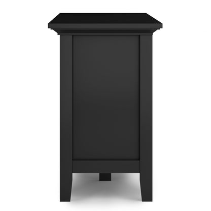 Side view of the Redmond - Handcrafted TV Media Stand, a black wooden rectangular piece with simple, straight legs and a plain panel design, isolated on a white background.