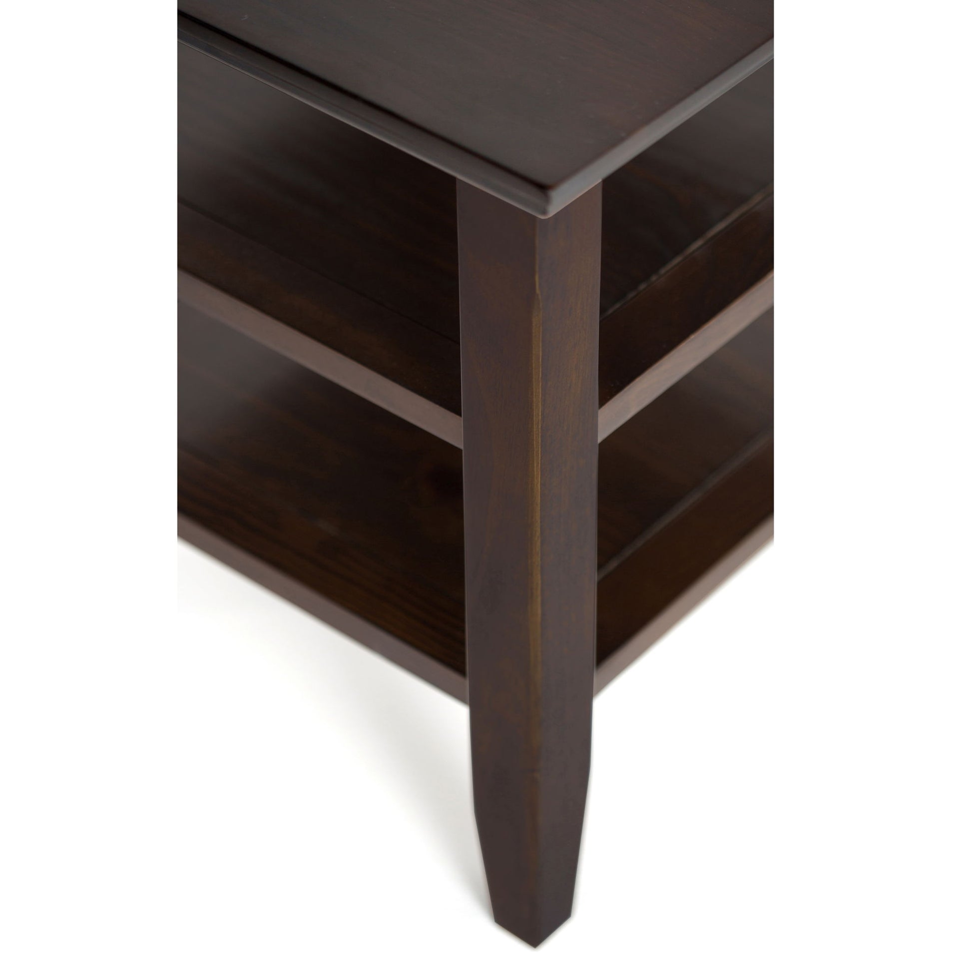 Close-up of the Acadian - Narrow Side Table, Handcrafted, featuring its dark brown finish, angled leg, and two lower shelves against a white background.