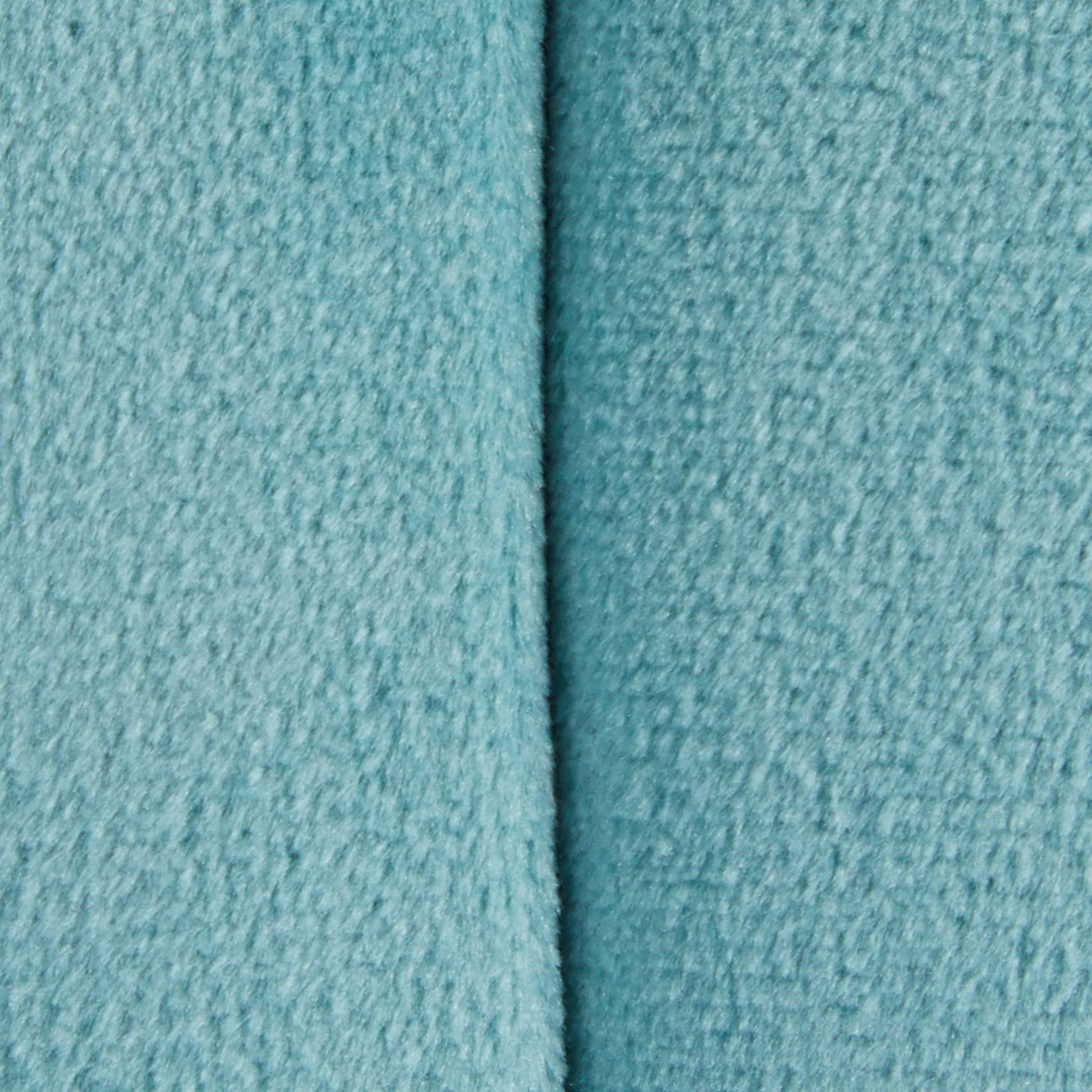 Close-up of the Braided - Versatile Round Ottoman in light blue, showing its textured fabric and a vertical seam down the center.
