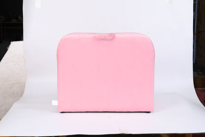 The Durable Design Kids Club Sofa, with smooth pink fabric and rounded top edges, sits against a plain white background. A small fabric fold accents the center of the sofa’s top.