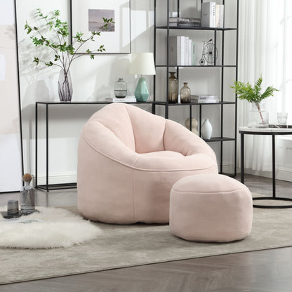 The Bedding Bean Bag Sofa Chair High Pressure Foam With Footrest in light pink sits on a gray rug in a modern living room, paired with minimalist decor, a black shelf, and a round table featuring a green plant.