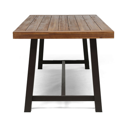 The Equilibrium Outdoor Dining Table features a slatted wooden top and sturdy black metal legs, shown from the short end against a plain white background.