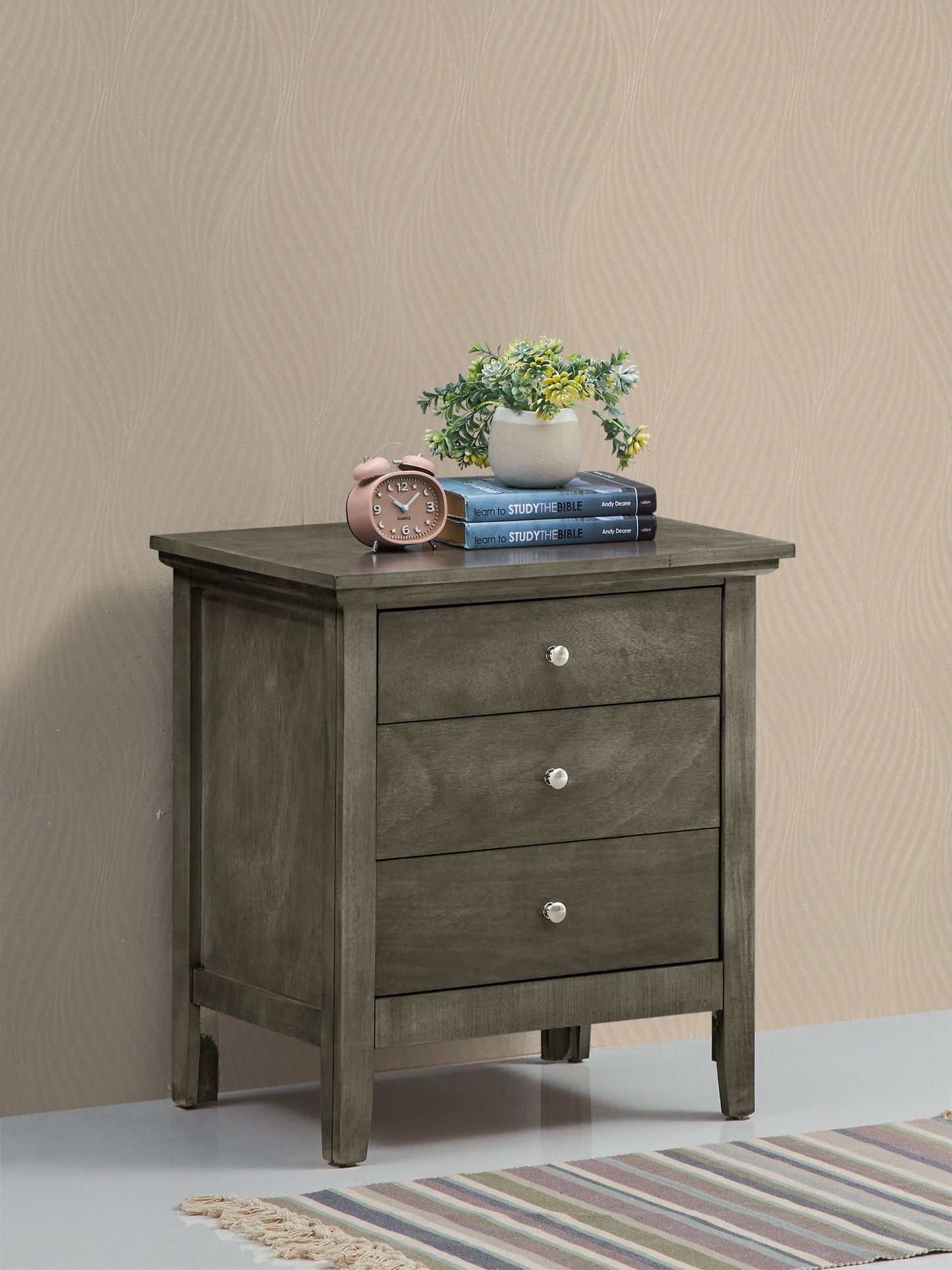 The Hammond 3 Drawer Nightstand with a plant placed on top.