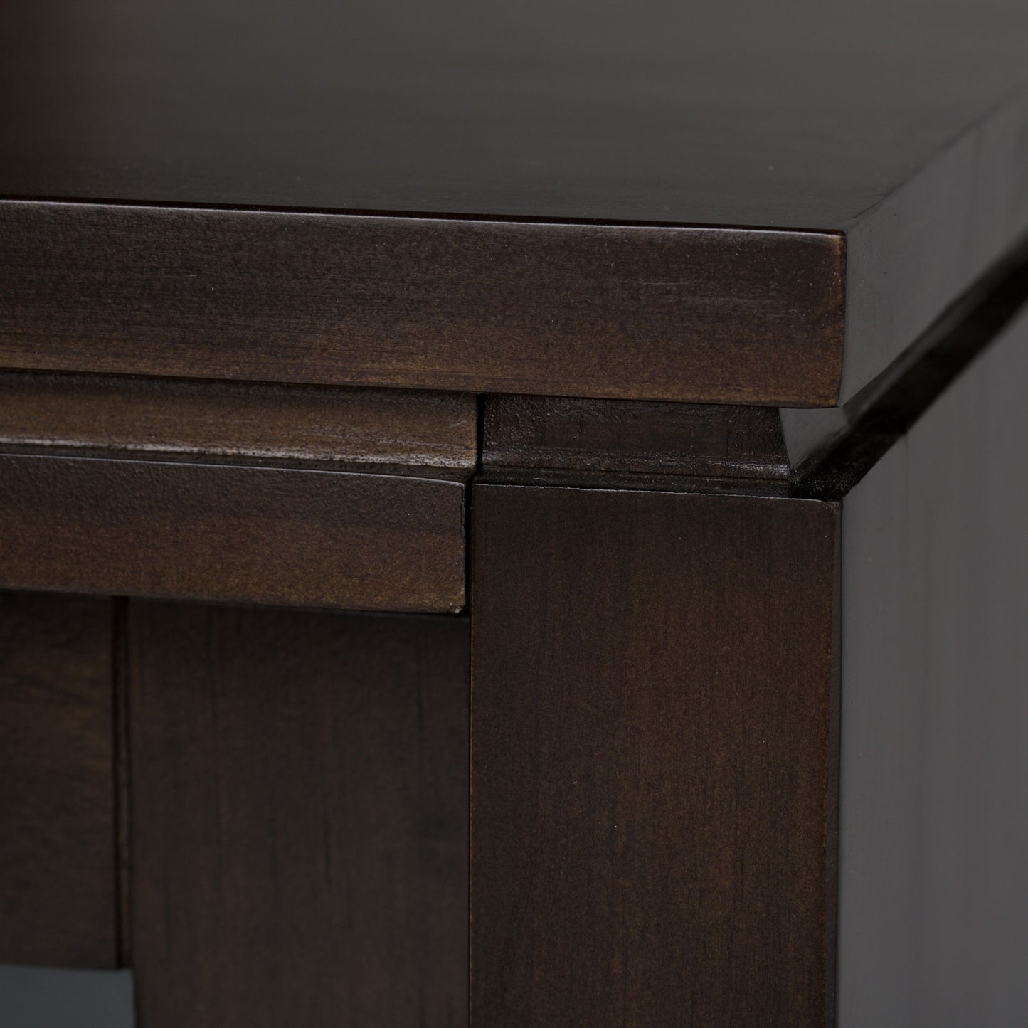 Close-up of the Cosmopolitan - Handcrafted TV Media Stand, highlighting its dark brown wood, smooth polished finish, visible grain patterns, and clean-lined tabletop with sturdy supporting legs.