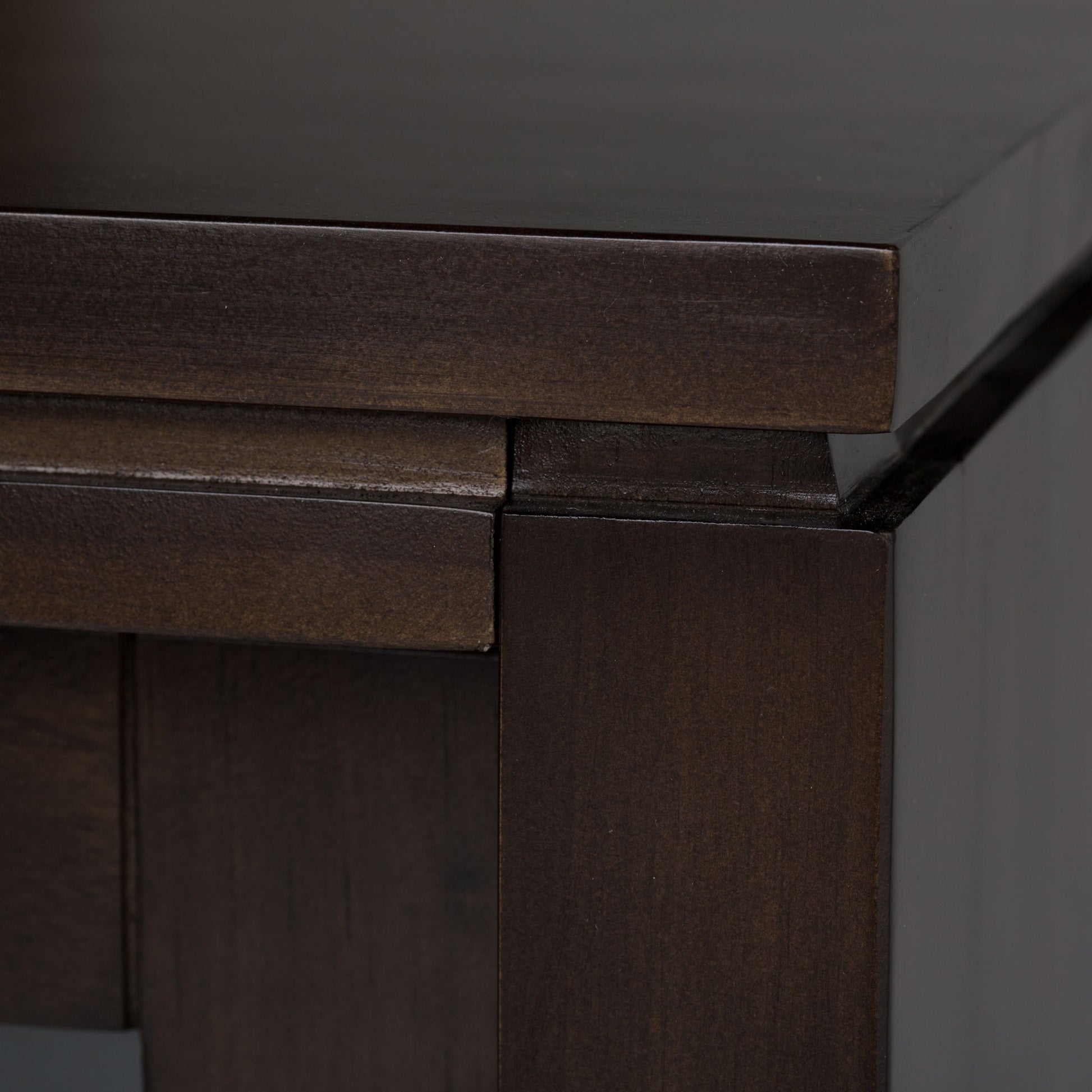 Close-up of the Cosmopolitan - Handcrafted TV Media Stand, highlighting its dark brown wood, smooth polished finish, visible grain patterns, and clean-lined tabletop with sturdy supporting legs.