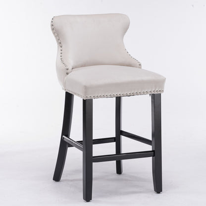 A set of 2 contemporary velvet wing-back barstools with button-tufted decoration, chrome nailhead trim, and wooden legs, shown against a plain white background.