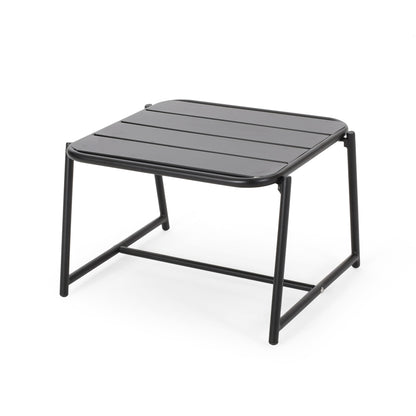 The Conrad - Side Table Outdoor is a black, square table with a slatted top and four tubular legs linked by crossbars.