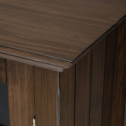 Close-up of the top and corner of the Bedford - Storage Media Cabinet, featuring its dark brown finish, visible wood grain, and detailed panel design.