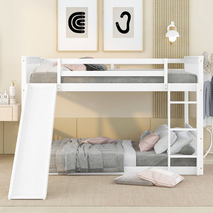 A modern kids' room with the Bunk Bed With Slide And Ladder in white. The lower bed has gray and pink bedding, the upper has gray bedding. Minimalist wall art and a reading lamp hang above a neutral-toned rug.