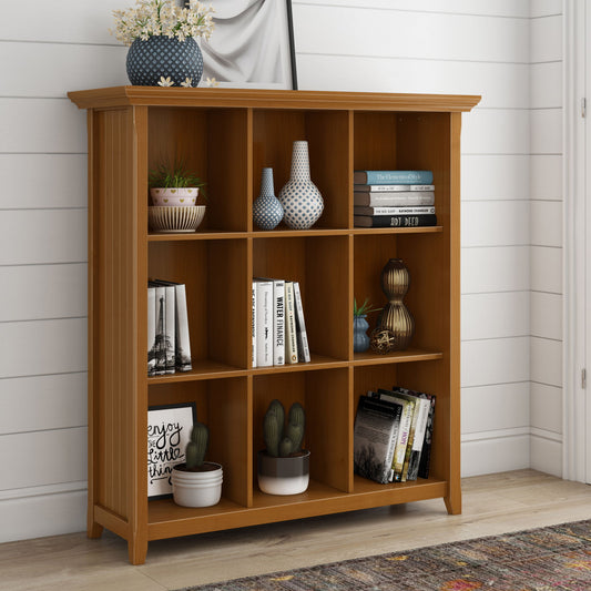 The Acadian - Handcrafted Cube Storage features nine open cubbies for books, plants, and decor. A floral vase tops the shelf, which stands against white shiplap walls on a colorful rug.