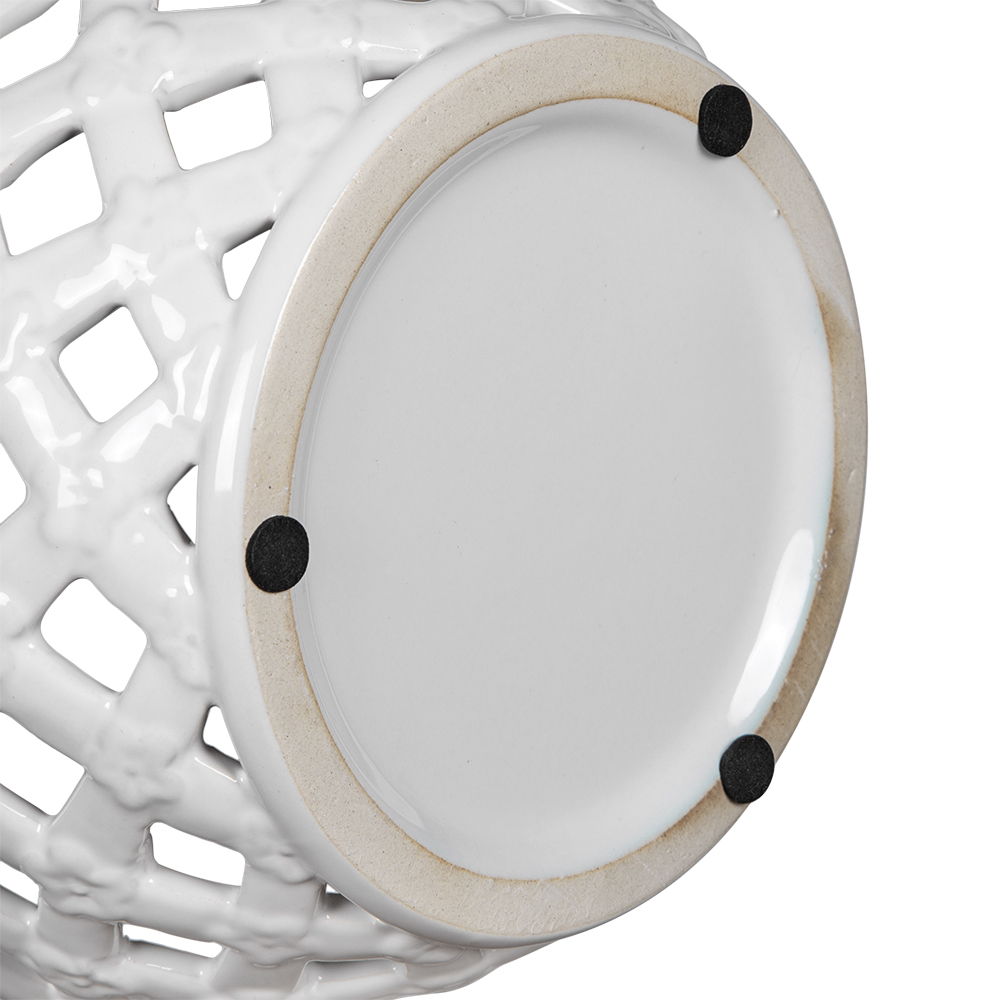 Close-up of the base of the Ceramic Lidded Jar With Lattice Design - White, featuring a round bottom with three small black pads that help protect surfaces from scratches.