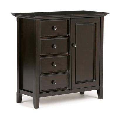 The Amherst - Handcrafted Medium Storage Cabinet is a dark wood piece with four left-side drawers and a right-side door, all with round metal knobs. It stands on short legs and features a simple, classic design.