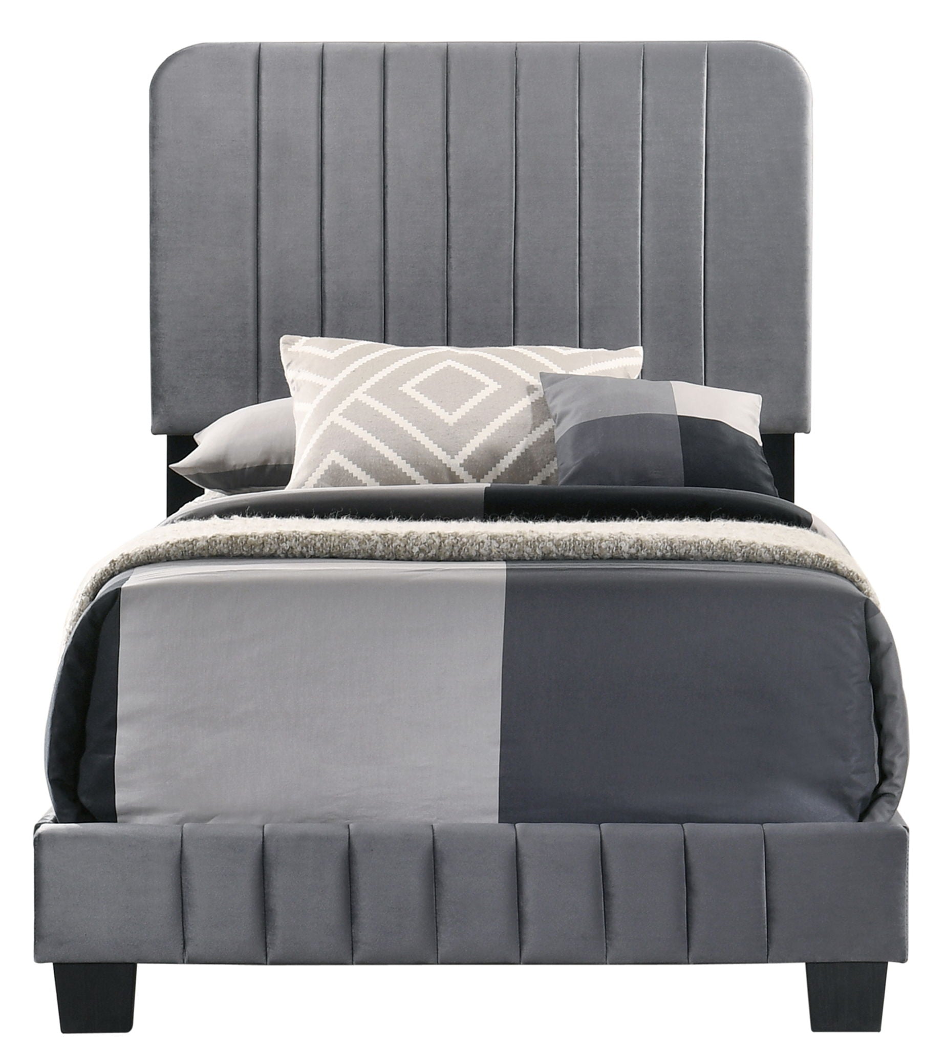 The Lodi - Bed features a tall, vertical-channeled gray upholstered headboard and is styled with geometric-patterned bedding in gray, white, and black, complemented by several pillows.