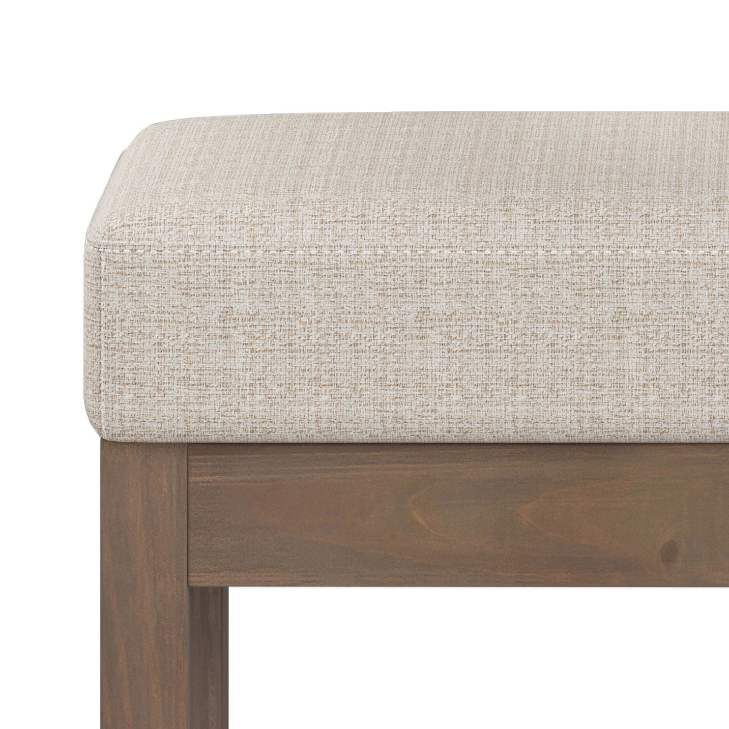 Close-up of the Milltown Upholstered Ottoman Bench featuring a cushioned seat in light beige textured fabric and a wooden frame with a rich brown finish.