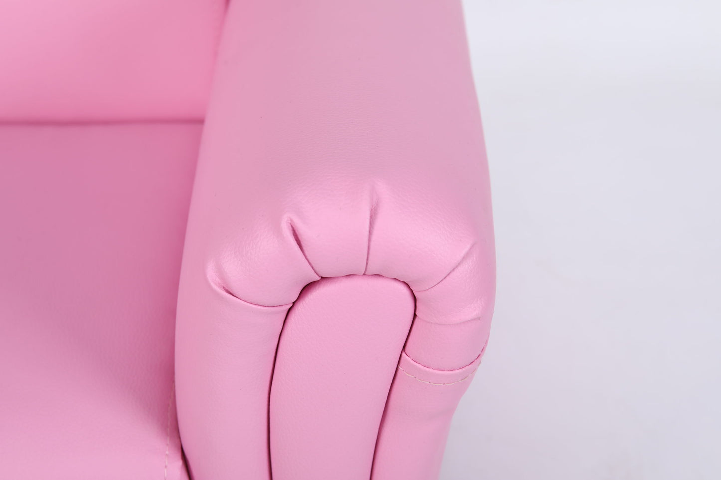 Close-up of the armrest on the Kids Club Chair Sofa / Sectional And Ottoman - Pink, featuring smooth, rounded edges and visible side stitching against a plain white background.