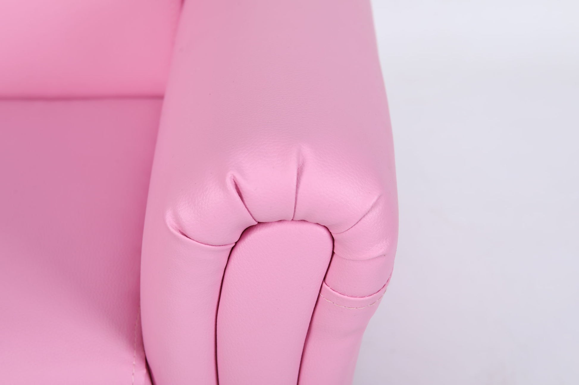 Close-up of the armrest on the Kids Club Chair Sofa / Sectional And Ottoman - Pink, featuring smooth, rounded edges and visible side stitching against a plain white background.