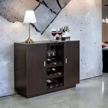 The Hazen - Wine Cabinet II - Espresso displays wine bottles and glasses, topped with a table lamp and wine setup, all set against a striking modern concrete wall with a bold cracked design.
