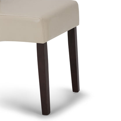 A close-up of the Avalon - Deluxe Parson, Dining Chair (Set of 2), featuring beige upholstery and dark wooden legs, shown against a white background.