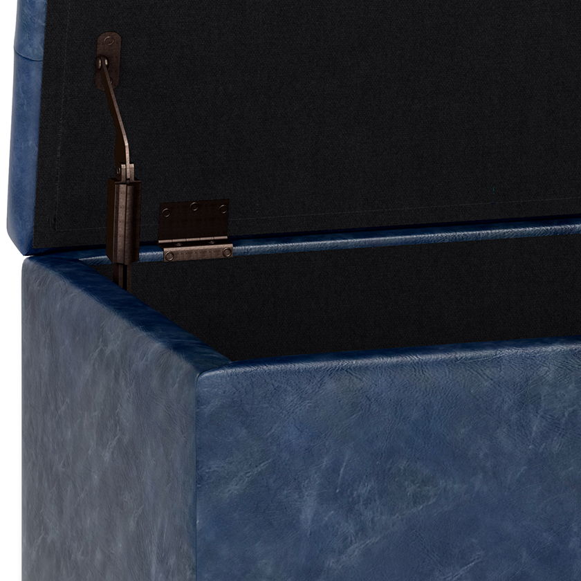Close-up of the Cosmopolitan - Upholstered Storage Ottoman featuring a blue faux leather exterior and black interior. The opened lid displays an inside corner hinge and support mechanism.