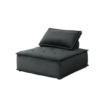The Anna Velvet Armless Lounge Chair features dark gray fabric upholstery, a tufted seat, and an angled back cushion, all showcased against a white background.