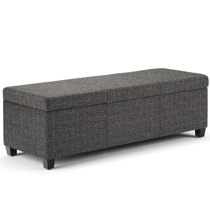 The Avalon Storage Ottoman Bench in dark gray features a rectangular, upholstered design with textured fabric, short black legs, and a lift-up cushioned top for storage—shown against a white background.