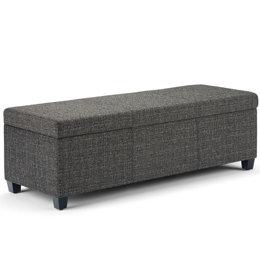 The Avalon Storage Ottoman Bench in dark gray features a rectangular, upholstered design with textured fabric, short black legs, and a lift-up cushioned top for storage—shown against a white background.