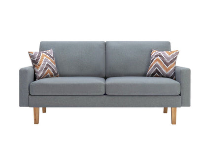 The Bahamas Minimalistic Sofa features a modern light gray design with wooden legs, two seat and back cushions, plus two orange, brown, and white zigzag-patterned throw pillows at each end.